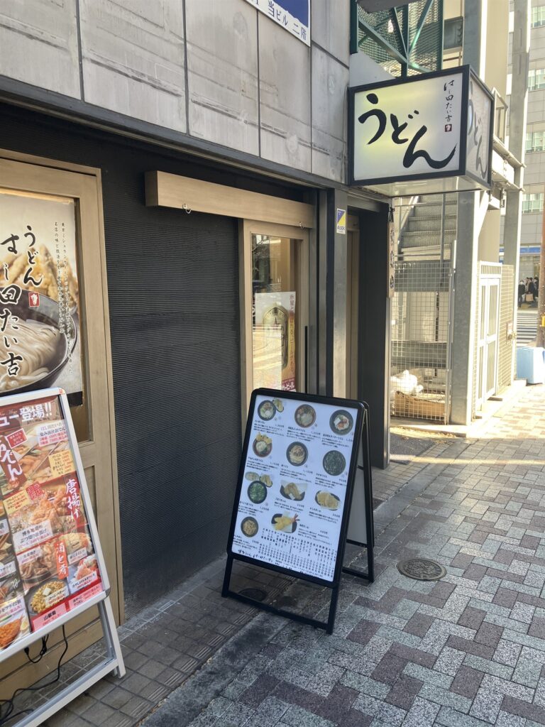 「うどん」の行灯看板が掛かるお店の外観