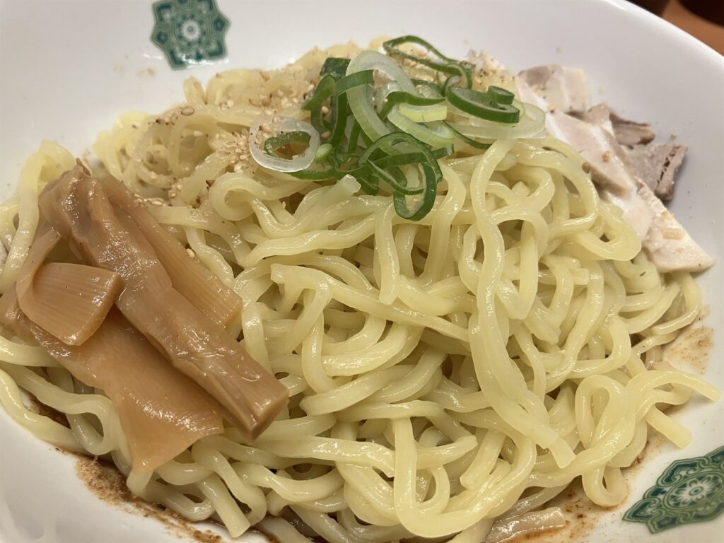 メンマやねぎ、チャーシューがのった汁なしラーメンの麺