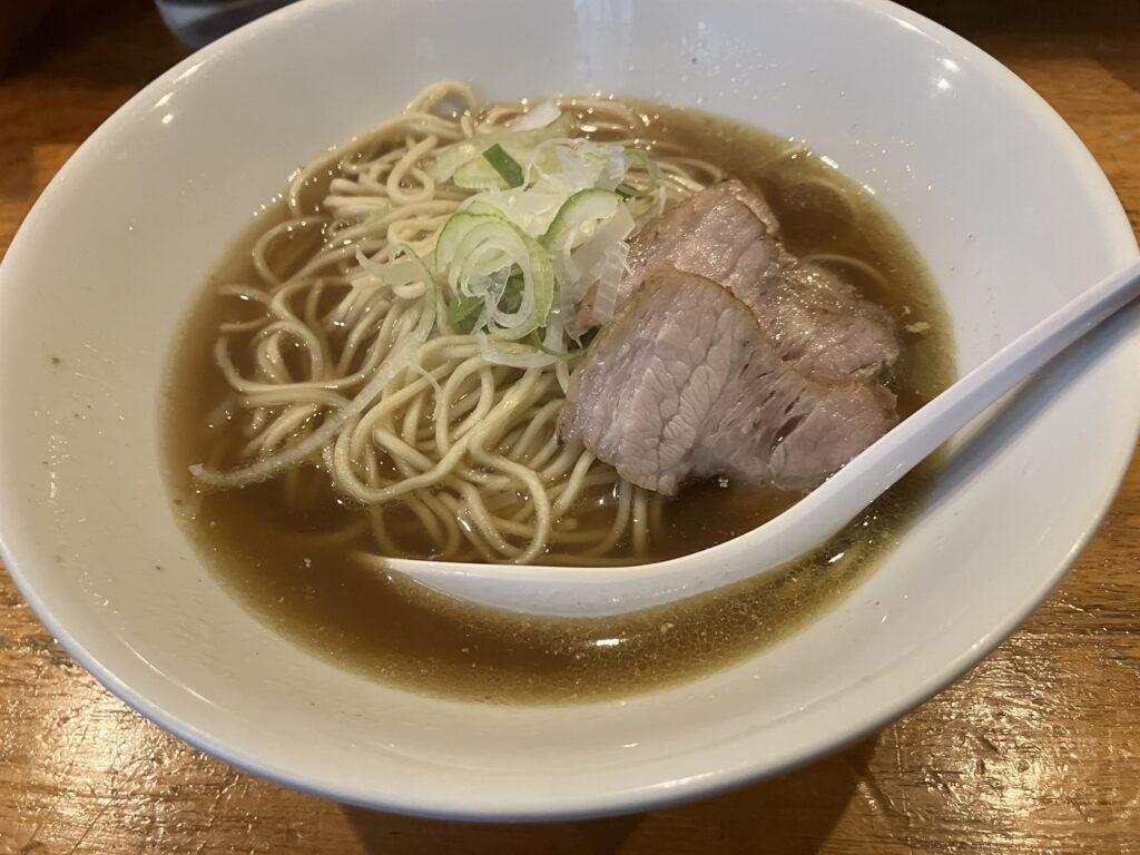 煮干しスープに浮かぶ細麺とねぎ、鶏肉