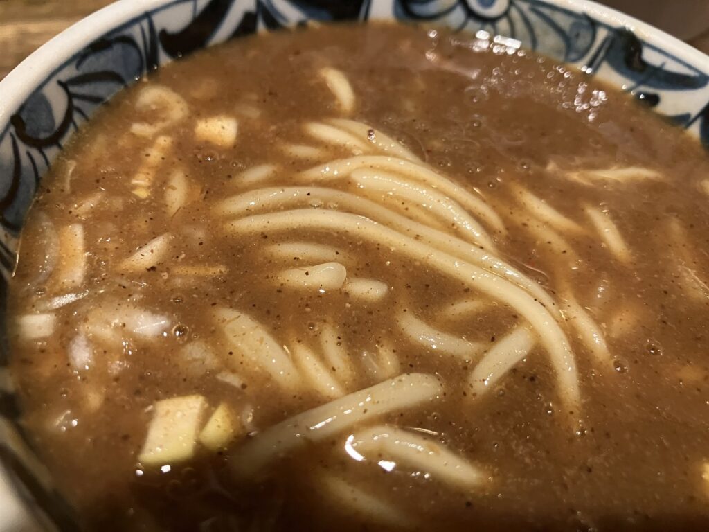 麺を浸した濃厚鶏つけ麵のつけ汁