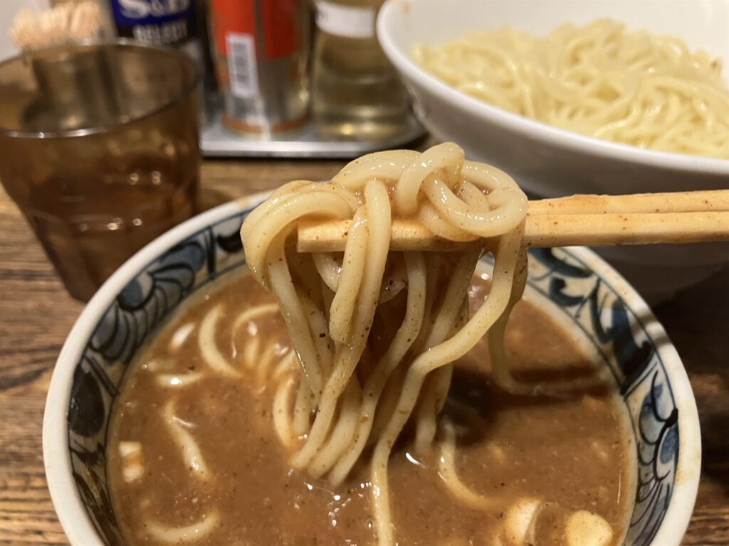 箸で持ち上げた麺に絡む濃厚なつけ汁