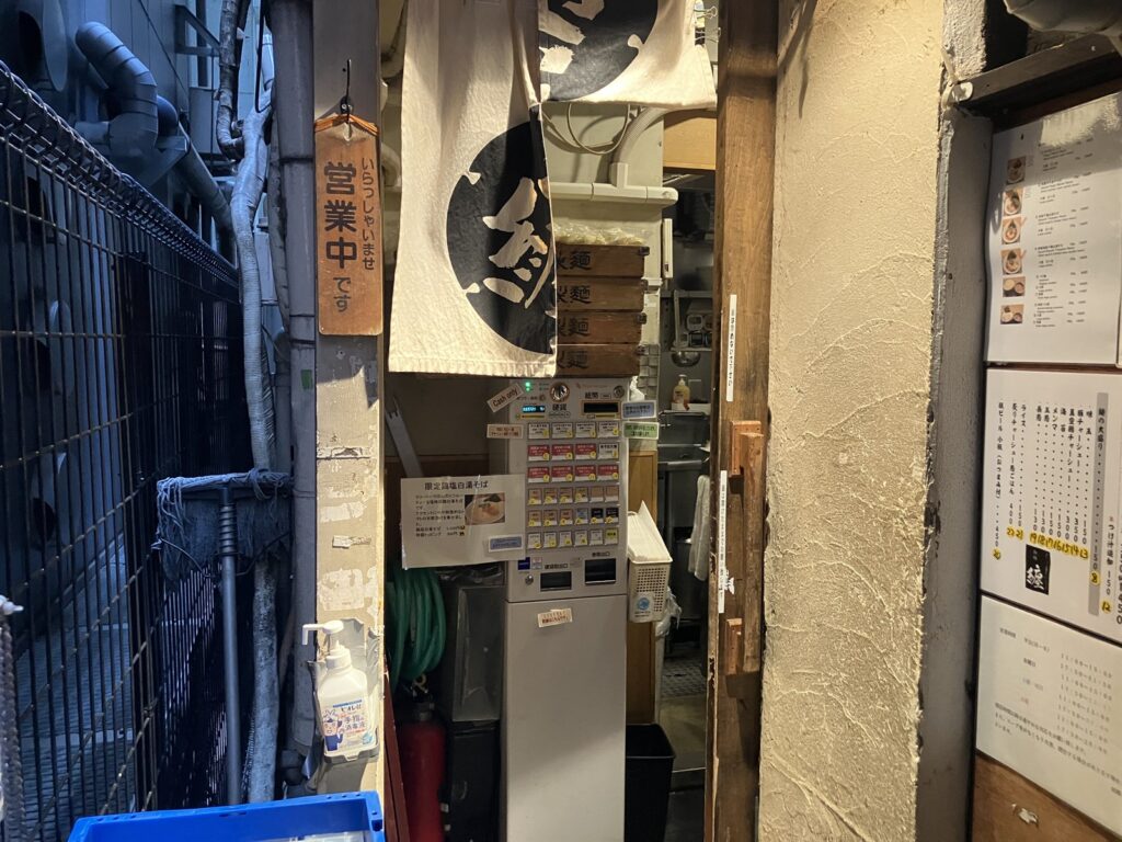 路地の奥にあるお店の入り口と券売機