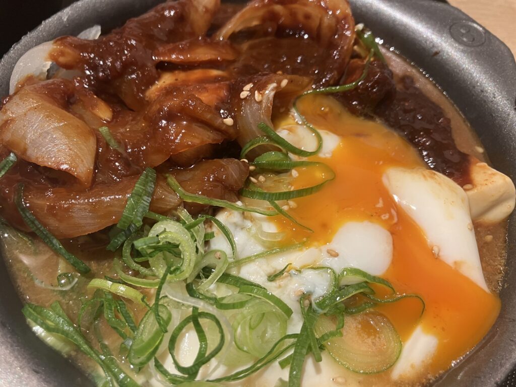 崩した温玉の黄身が味噌ダレに広がる様子