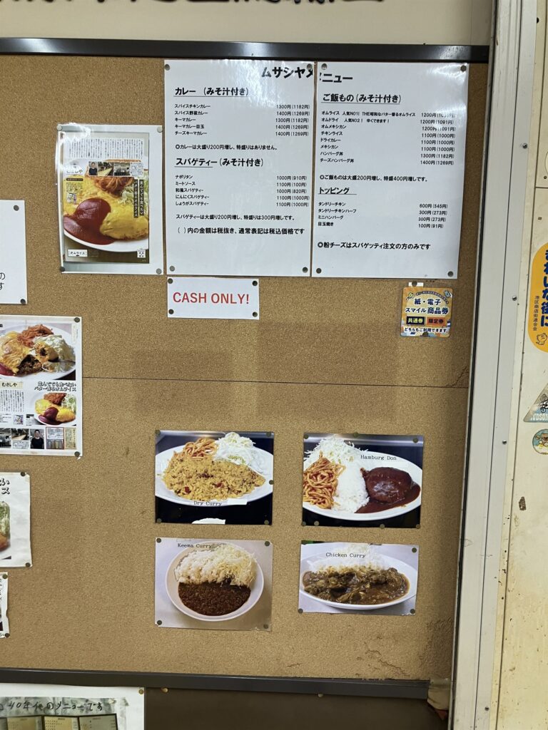 店内のコルクボードに貼られたメニューと料理写真