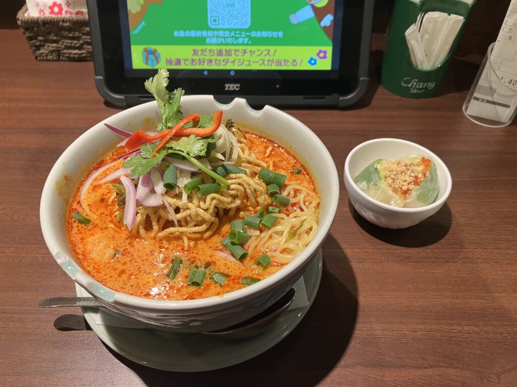 赤いスープにパクチーと赤唐辛子がのったカオソイの全体