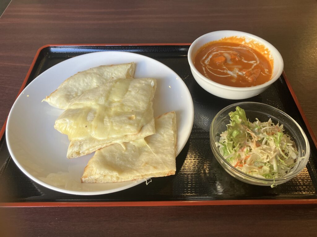 チーズナン・バターチキン・サラダがのったランチセットのトレー