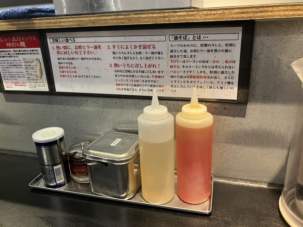 卓上に置かれたお酢とラー油、刻み玉ねぎ