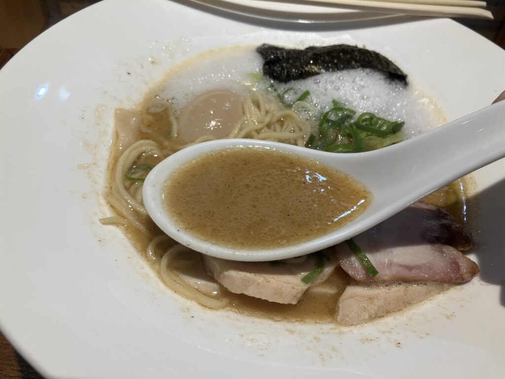 レンゲにすくった濃厚な鶏のスープ