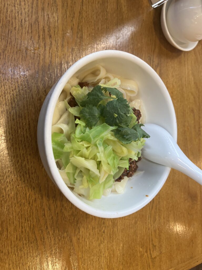 やや大きめの丼に盛られた刀削麺と中央の肉味噌